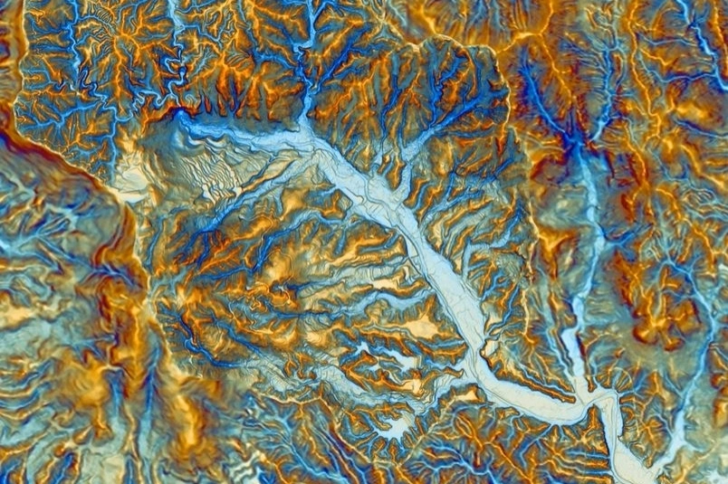Topographic map visualization showing complex terrain with valleys, eroded hillsides, and shaded Yin-Yang style representation highlighting elevation differences