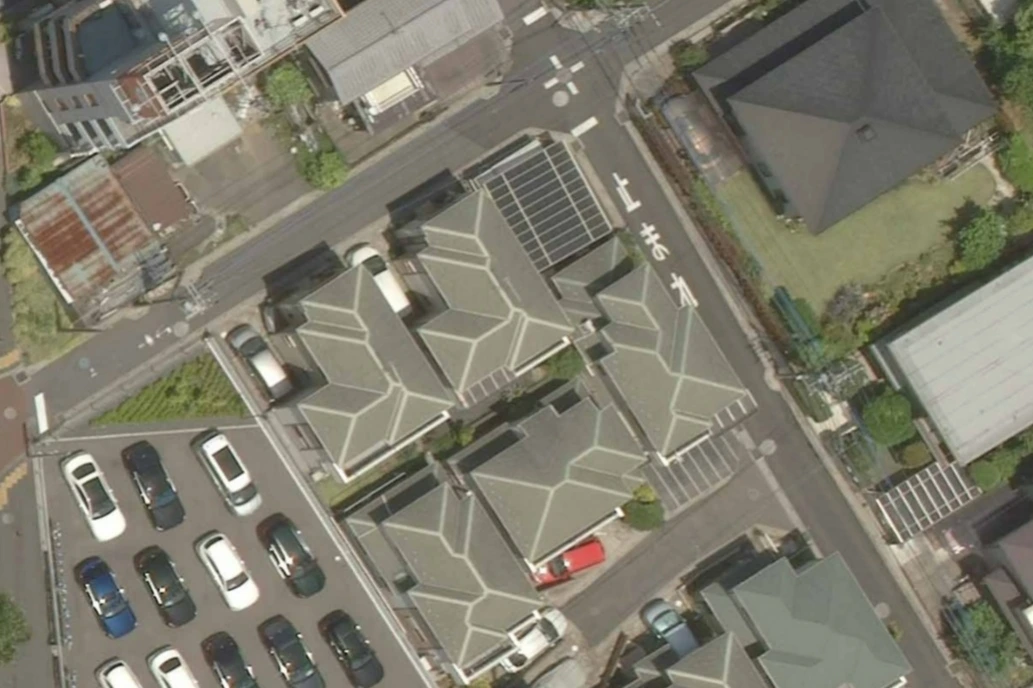 Aerial view of residential neighborhood with houses, parking lot, and street intersection